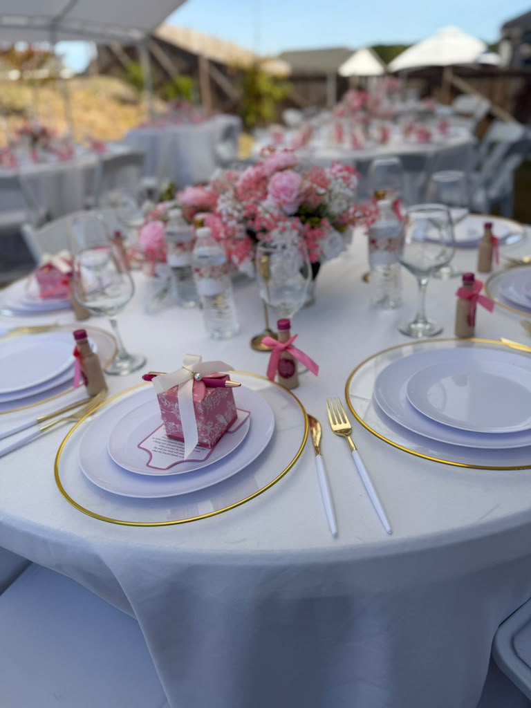 Round reception tables with pink rose centerpieces and gold flatware at an Atlanta event